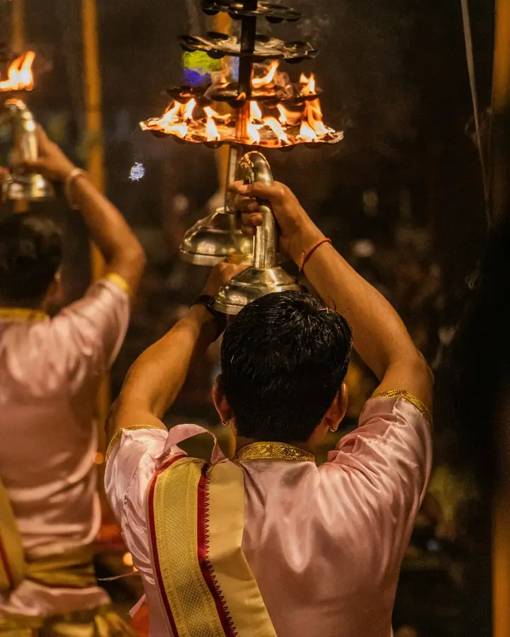 A priest performing aarti with a lamp