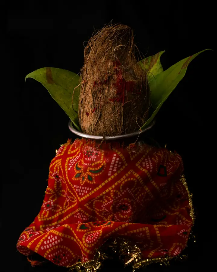 A kalash with a coconut and mango leaves